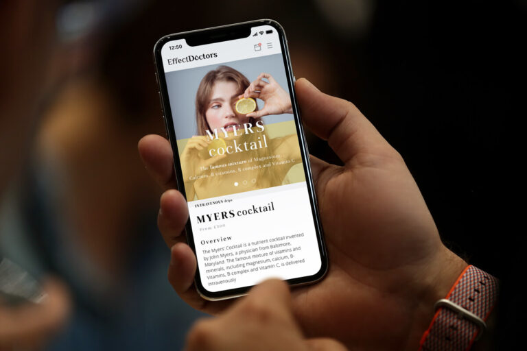 A mobile phone showing a picture of a woman holding a lemon up to her eye