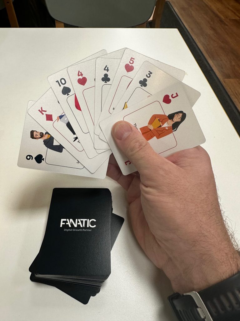 A hand holding a fan of playing cards, displaying a 6, 10, king, 4, 9, 5, jack, and queen; a 