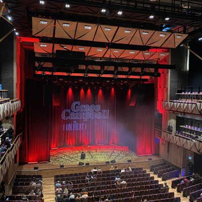 A theater stage with red curtains, spotlighted with 