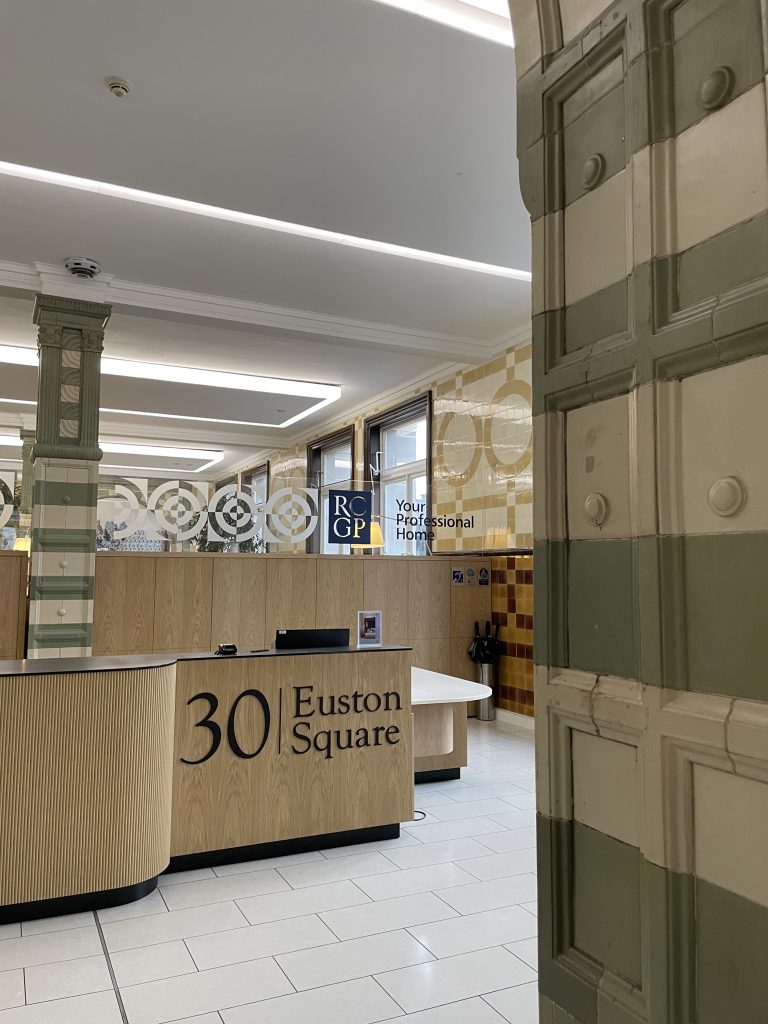The interior of a modern lobby at 30 Euston Square, featuring a reception desk and decorative wall panels.